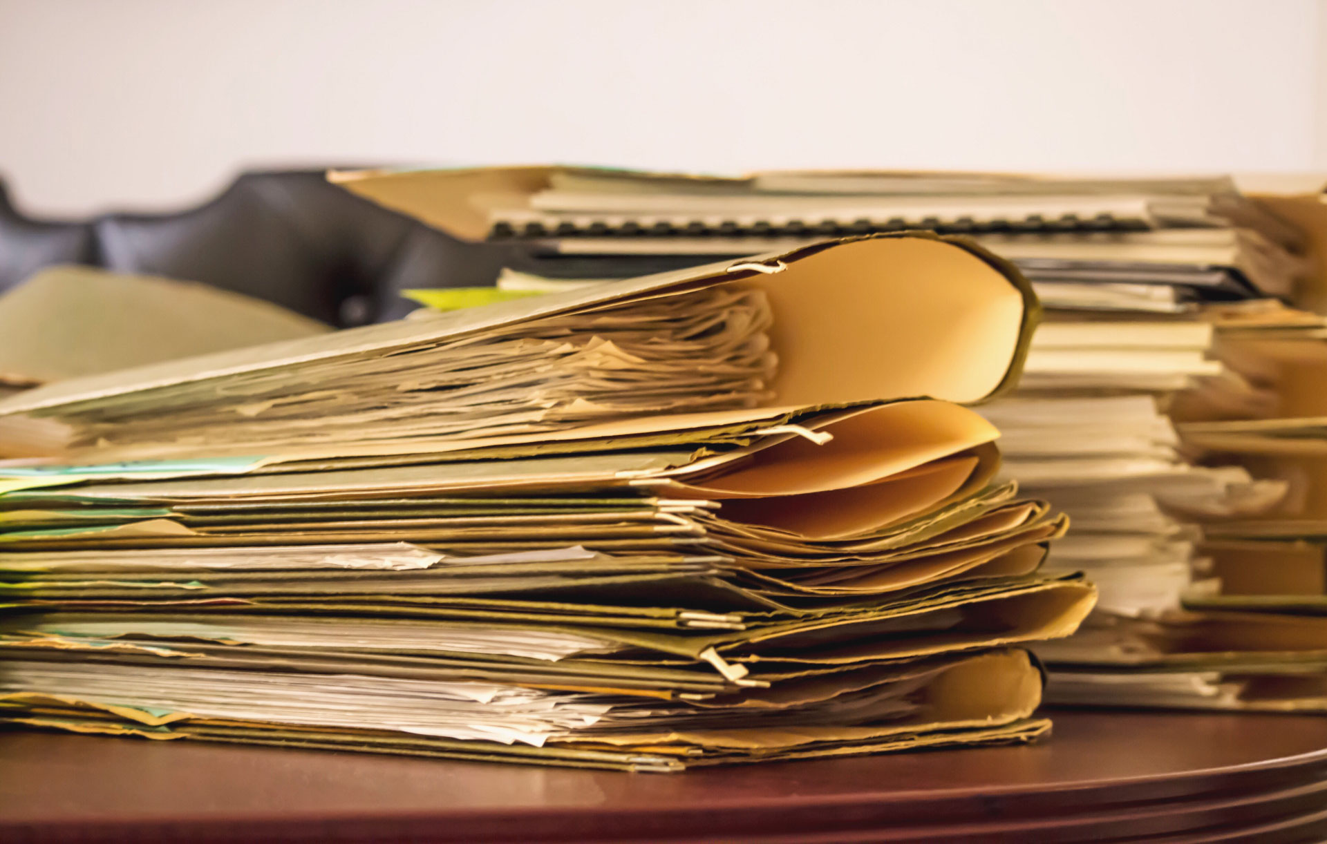 Stapel von Papierakten auf einem Schreibtisch – typischer Ausgangspunkt für Digitalisierung